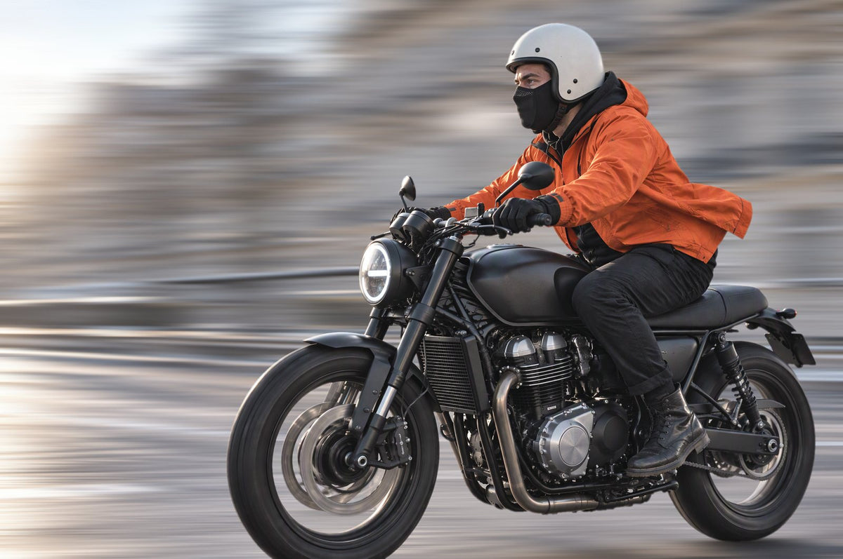 Pilote et passagère à moto sur un pont en hiver, demi-cagoules noires